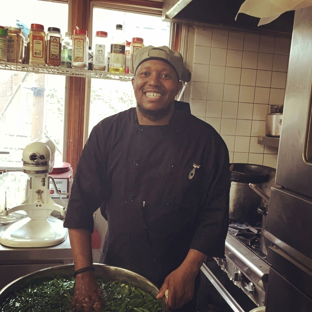Chef Poe preparing fresh greens in a professional kitchen